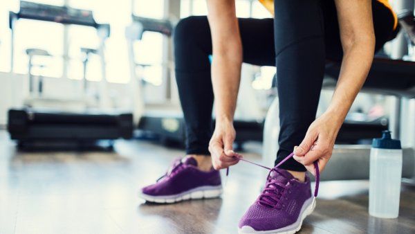 Woman at gym tying running shoes