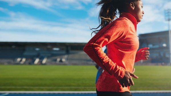 A female athlete runs on a track.