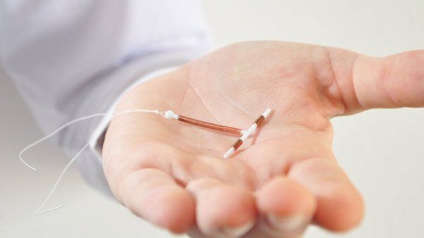 Hand holding a copper IUD contraceptive