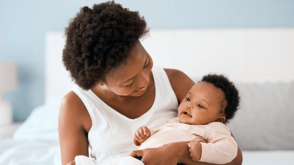 Black mother holding her baby, smiling