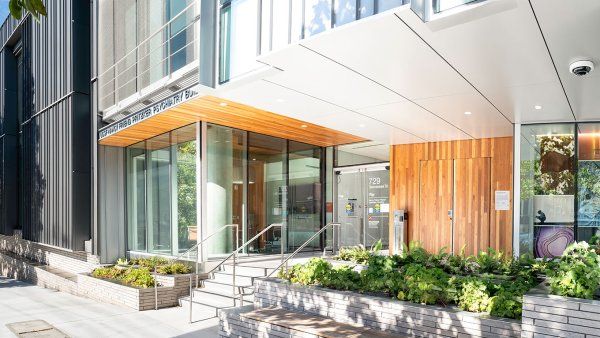 An entrance to the Nancy Pritzker building. The entrance features wood panelling and plants