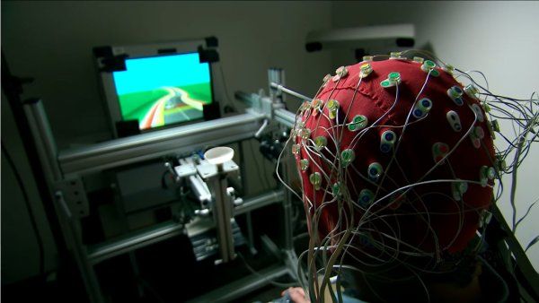 A person wearing brain activity detectors plays a video game
