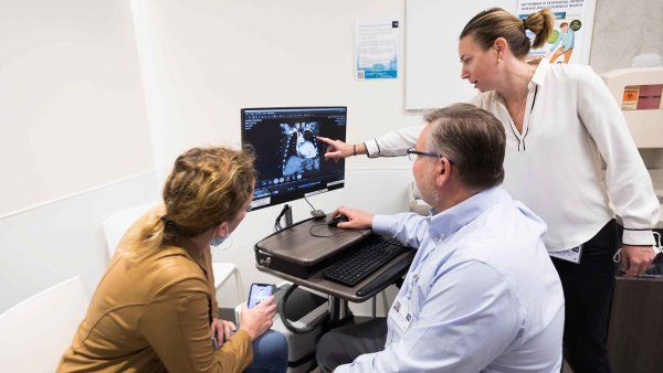 Three people looking at a heart scan on a monitor.
