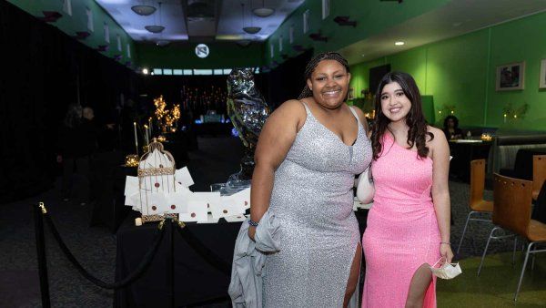 两名十几岁的女孩在美国旧金山贝尼奥夫儿童医院的舞会上合影。一件是银色的晚礼服，另一件是粉红色的。