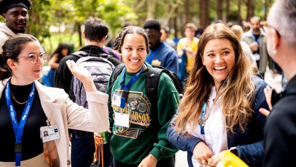 A group of U C S F staff and graduate students smile as they stand outdoors during a fall celebration.