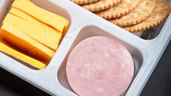 A packaged tray of processed cheese, ham, and crackers for children.