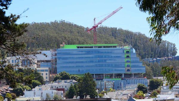The Bakar Research and Academic Building under construction, with a tower crane above the partially completed structure.