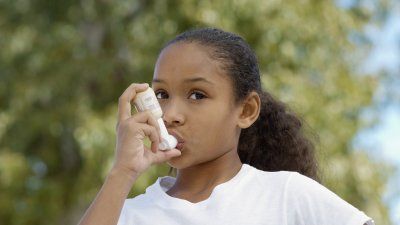 Young girl using an inhaler 