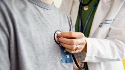 doctor listening to patient's chest with stethoscope