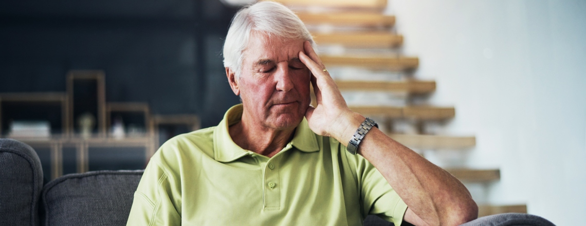 Man rubbing his temples. 