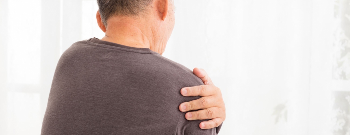 senior man gripping his shoulder in pain