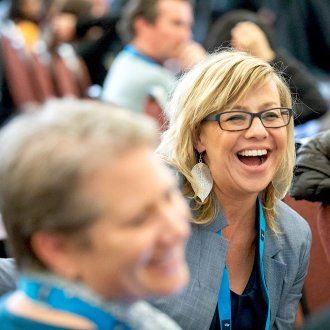 Kim LaPean laughing in the audience during the 2018 Communicators’ Conference 