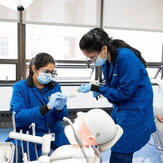 Dheepthi Rajasekar, left, and Monika Naik, 3rd-year students in the UCSF International Dentist Pathway (IDP) program that prepares foreign dentists for U.S. practice, pour plastic into a mold to make a dental impression, in the UCSF School of Dentistry Sim Lab