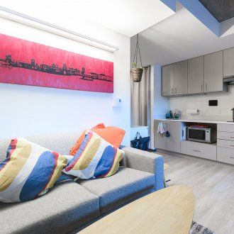 A couch sits along one wall with a view of the kitchen beyond it