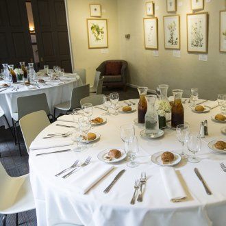 Circular tables covered with white tablecloths and set with silverware