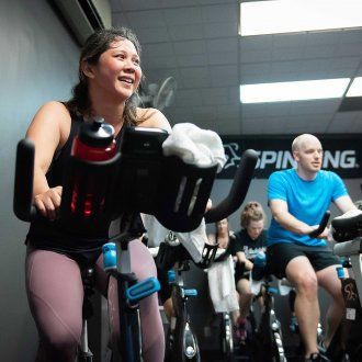 During a spin class participants grin while they work up a sweat