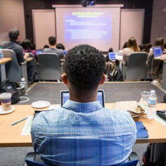 A pharmacy student watches a presentation during class