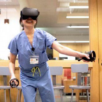 A lab assistant uses a VR headset and VR Space in the Makers Lab to virtually navigate human blood vessels