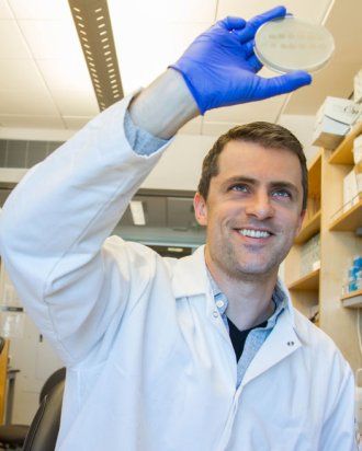 Joseph Bondy-Denomy holding petri dish in his lab