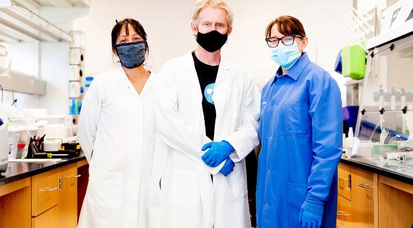 Vida Ahyong, Joe DeRisi, and Emily Crawford in face masks, lab coats, and gloves.
