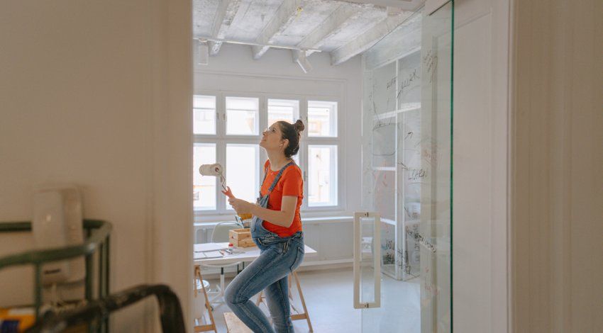 A pregnant woman paints a nursery
