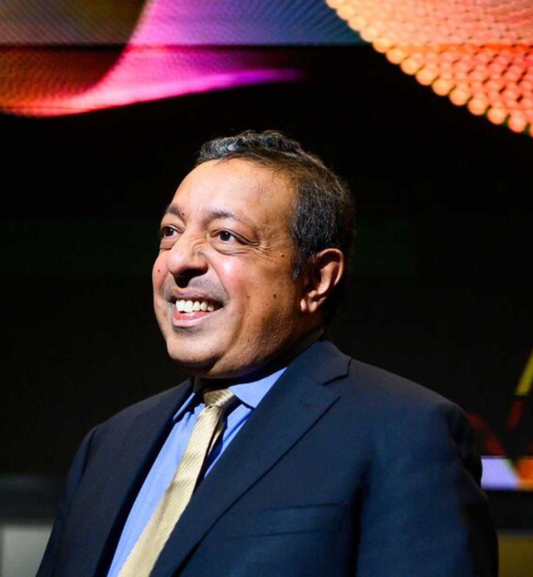  Atul Butte smiles in front of large colorful screen