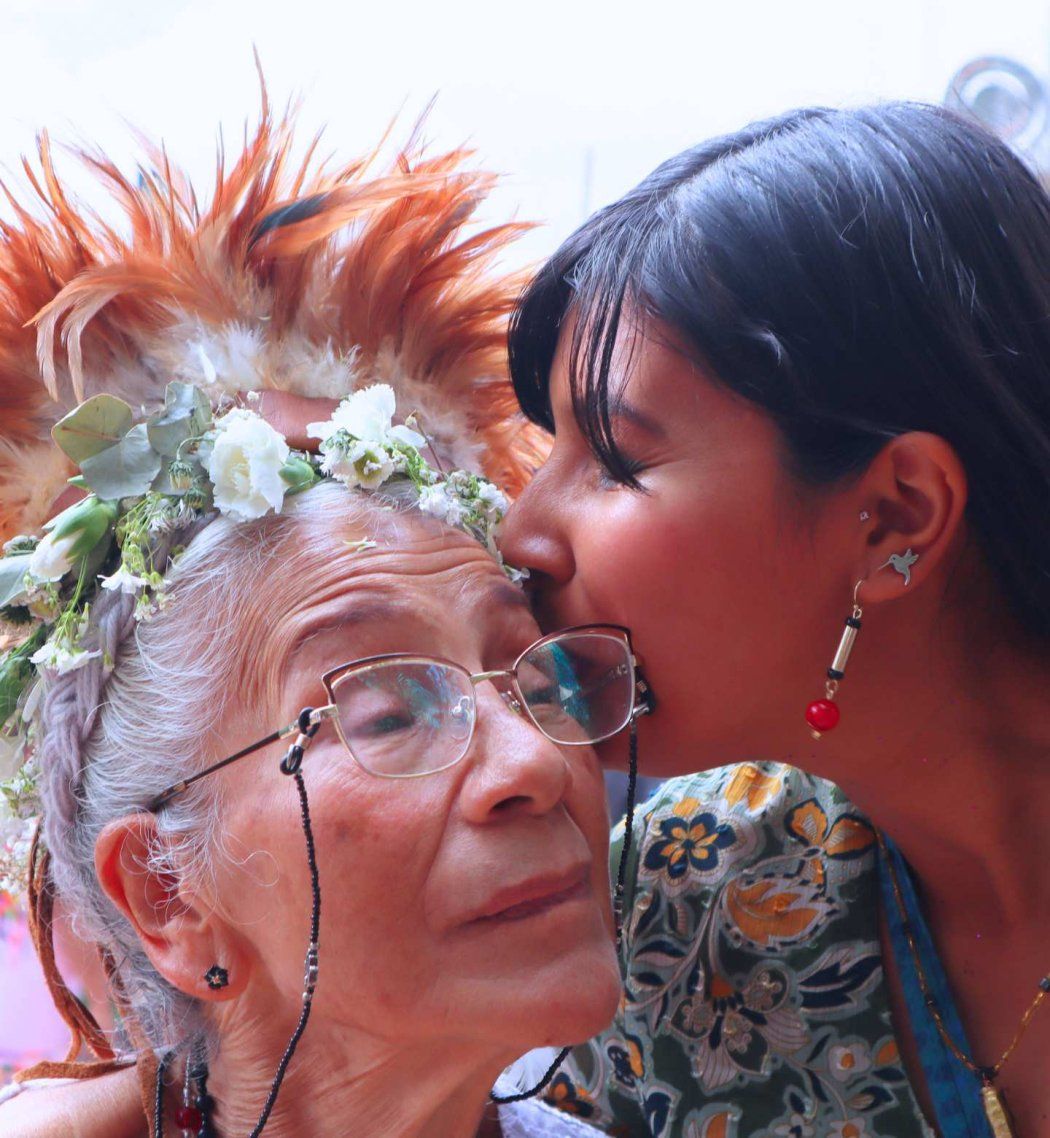Perez-Aguilar kisses elderly indigenous woman wearing fresh flowers in hair