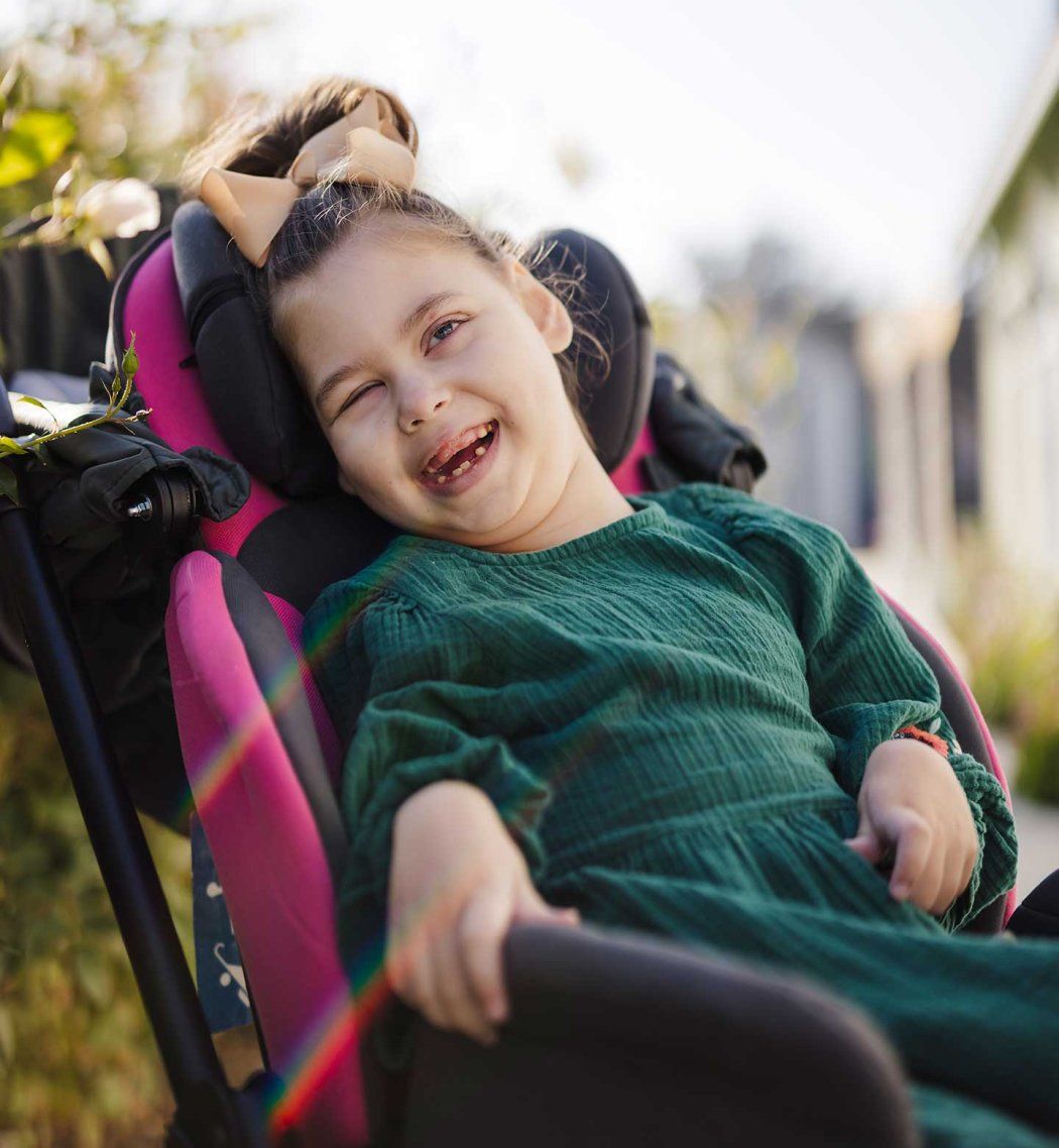 Seven-year-old Hannah Detlefsen smiles as she sits in her wheelchair. Gould Syndrome has caused her physical and cognitive delays, but she has become more expressive over time.