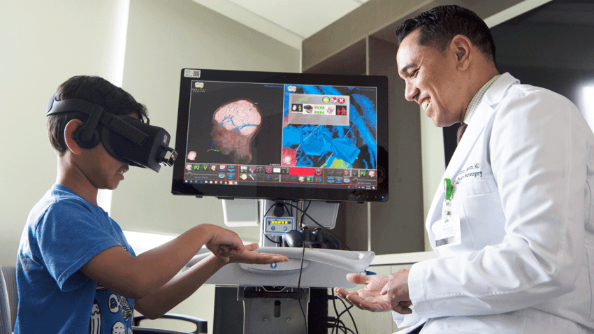 Dr. Auguste with his son testing the VR technology. 