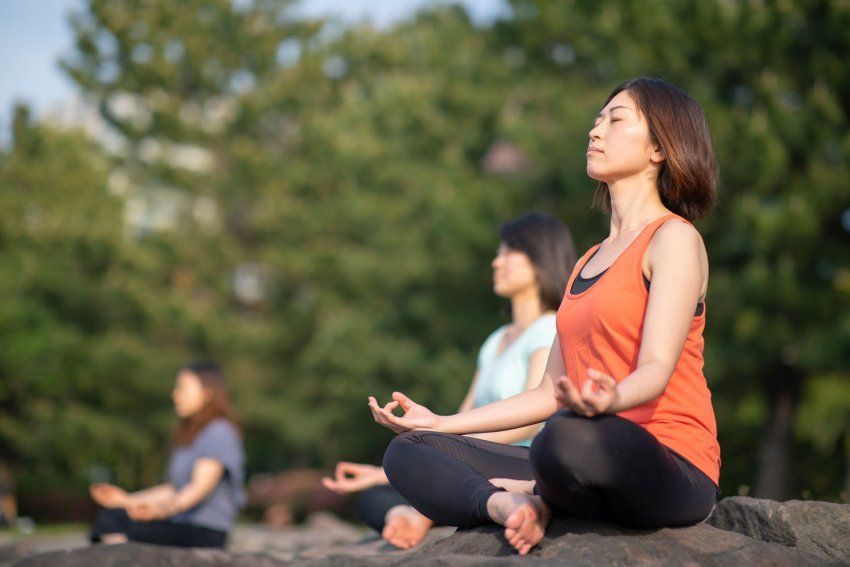 Three women meditating outisde