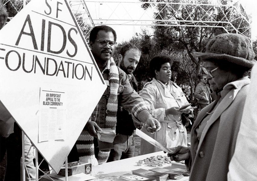 People handing out information at San Francisco AIDS Foundation table at Martin Luther King Jr. memorial celebration in San Francisco; sign reads “An Important Appeal to the Black Community.”