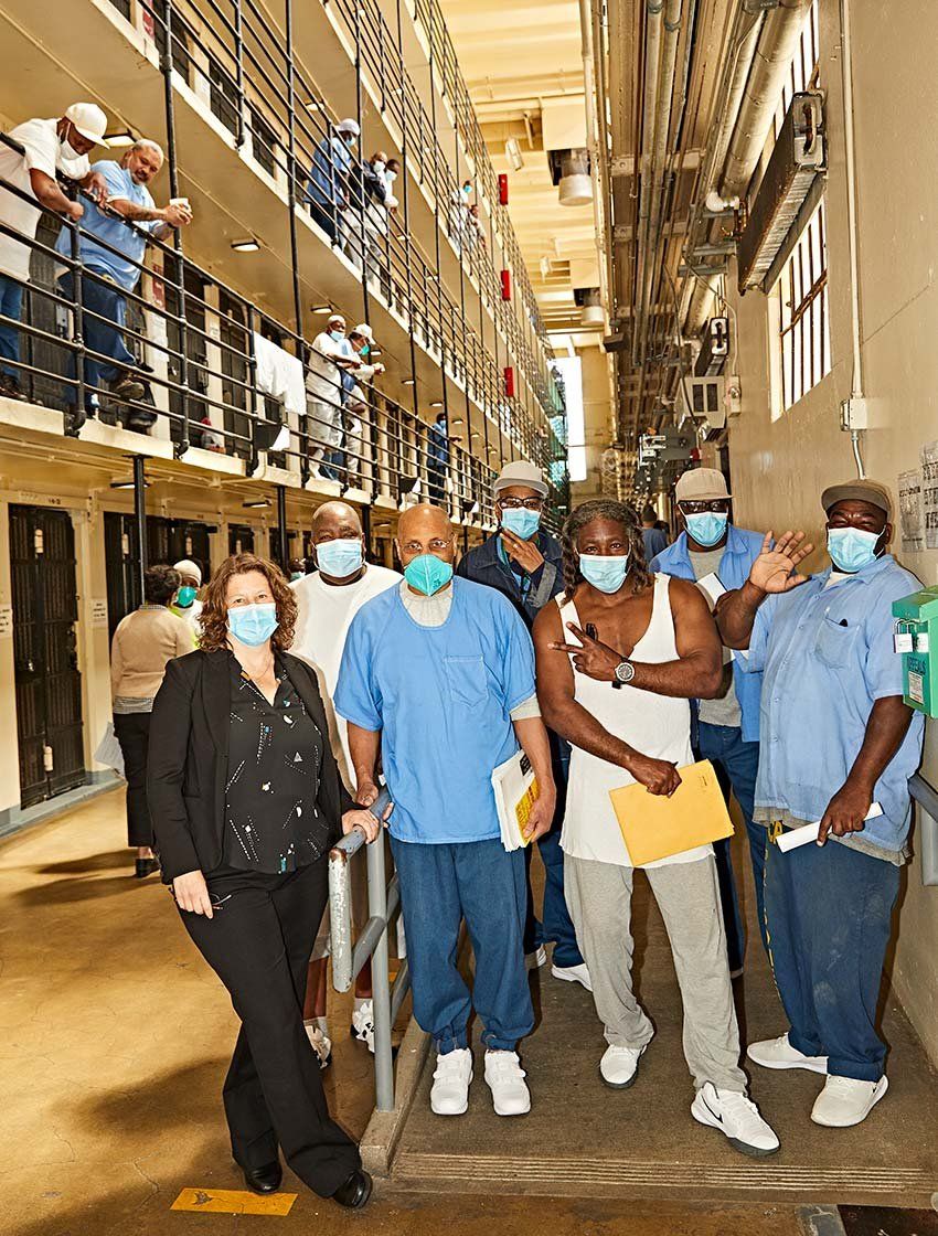 Photo of Brie Williams with incarcerated men at San Quentin State Prison.