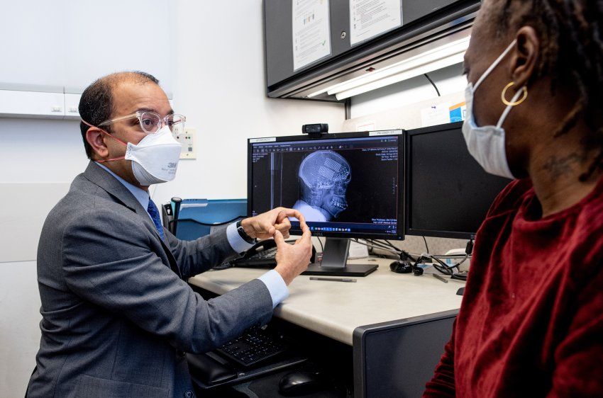 Rashetta Higgins listens to Vikram Rao as he explains placing how they will place electrodes on the surface of her brain