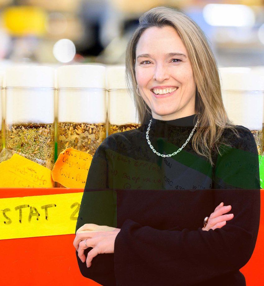 Leanne Jones stands and smiles against an abstract backdrop of research imagery