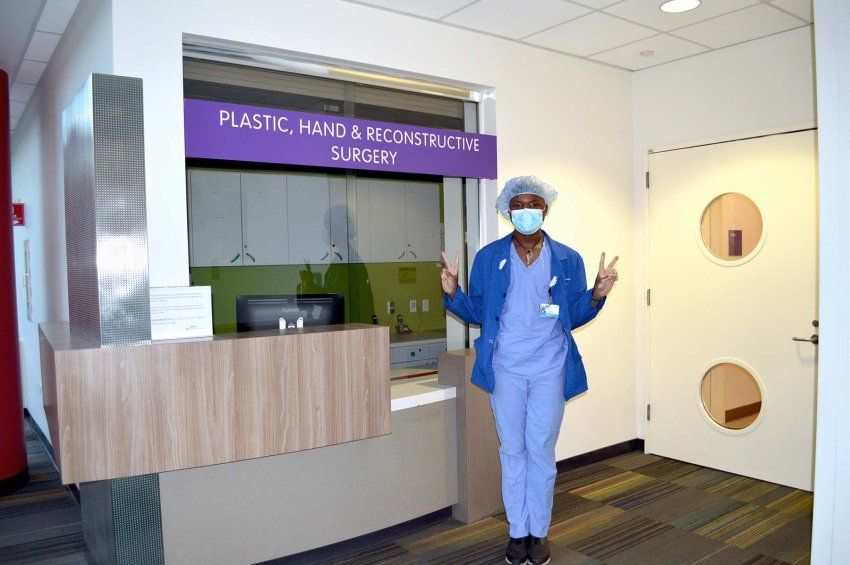 Ronell McZeal poses near the Plastic, Hand, and Reconstructive Surgery unit sign at ZSFG