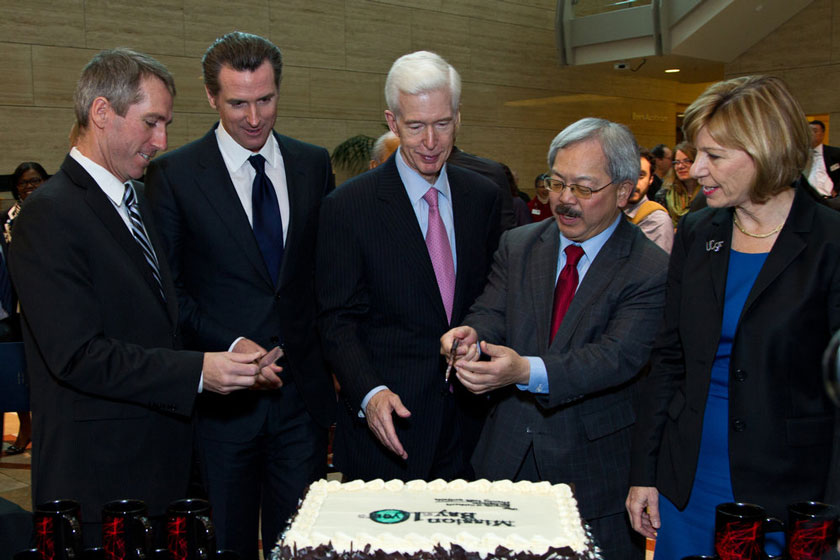 Cutting a cake marking the 10th anniversary of the UCSF Mission Bay campus are, from left, Chris Haskell, PhD, Mission Bay Site Head for Bayer Healthcare; Lt. Gov. Gavin Newsom; Nobel laureate and UCSF Chancellor Emeritus J. Michael Bishop, MD; former Gov. Gray Davis, San Francisco Mayor Ed Lee; and UCSF Chancellor Susan Desmond-Hellmann, MD, MPH.